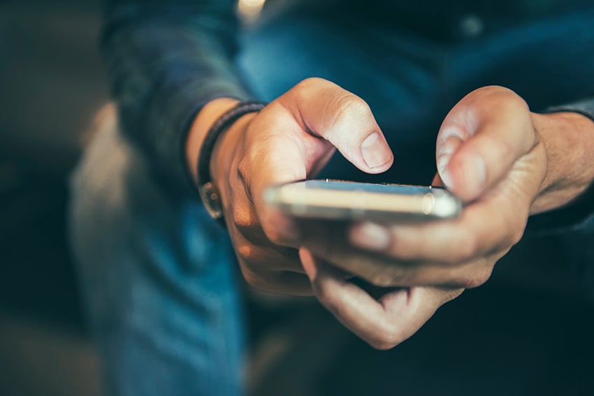 938786704 Persona enviando mensaje de texto en teléfono móvil